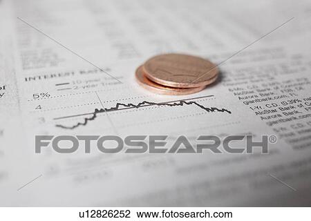 Stock Image - Studio shot of coins on financial newspaper. Fotosearch