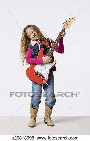 Stock Photo - Studio shot of girl (8-9) playing electric guitar, studio shot. Fotosearch