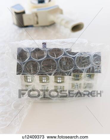 Stock Image - Studio shot of house wrapped in bubble wrap. Fotosearch