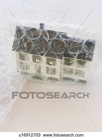 Stock Image - Studio shot of house wrapped in bubble wrap. Fotosearch