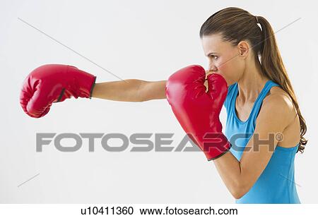 Stock Image - Studio shot of woman boxing. Fotosearch