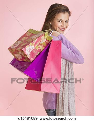 Studio shot of woman holding shopping bags View Large Photo Image Stock Photo - Studio shot of woman holding shopping bags. Fotosearch