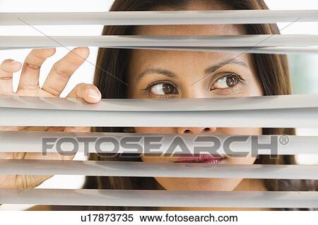 Studio shot of woman looking through blinds View Large Photo Image Stock Photography - Studio shot of woman looking through blinds. Fotosearch