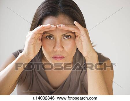 Studio shot of woman shielding eyes View Large Photo Image Stock Photograph - Studio shot of woman shielding eyes. Fotosearch
