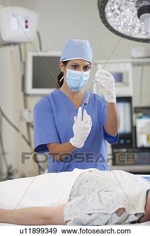 Surgeon preparing patient for surgery View Large Photo Image Stock Photo - Surgeon preparing patient for surgery. Fotosearch