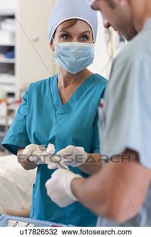 Stock Image - Surgeons holding tools. Fotosearch