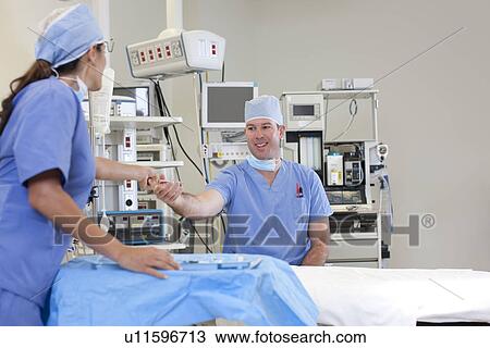 Stock Image - Surgeons in operating room. Fotosearch