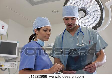 Surgeons looking at x-ray View Large Photo Image Stock Photograph - Surgeons looking at x-ray. Fotosearch