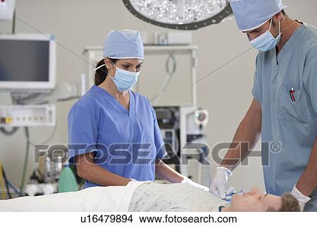 Surgeons preparing patient for surgery View Large Photo Image Picture - Surgeons preparing patient for surgery. Fotosearch