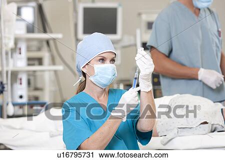 Surgeons preparing patient for surgery View Large Photo Image Stock Image - Surgeons preparing patient for surgery. Fotosearch