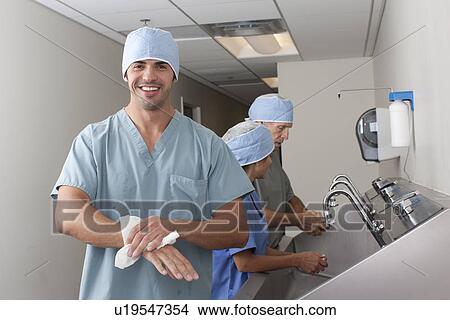 Picture - Surgeons washing hands in hospital. Fotosearch