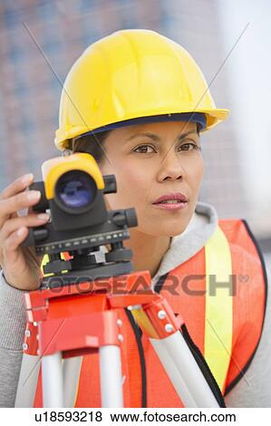 Stock Photo - Surveyor using a theodolite instrument. Fotosearch