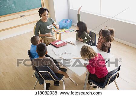 Stock Photo - Teacher and children (6-7) at school. Fotosearch