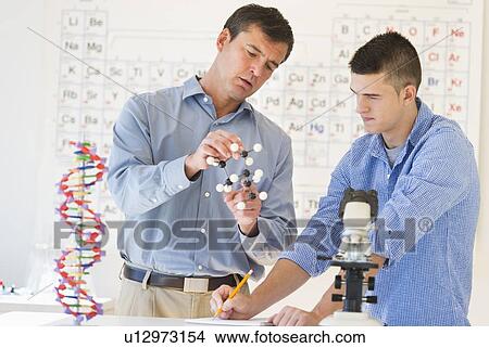 Picture - Teacher and teenage (16-17) student in chemistry lab. Fotosearch