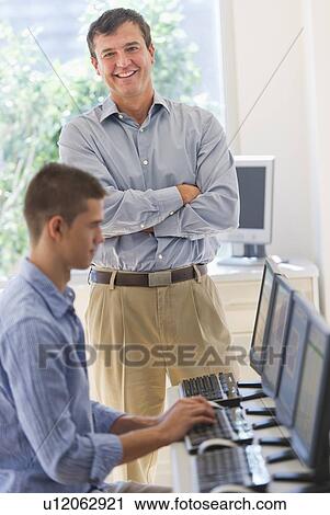 Teacher and teenage student (16-17) in computer lab View Large Photo Image Stock Image - Teacher and teenage student (16-17) in computer lab. Fotosearch