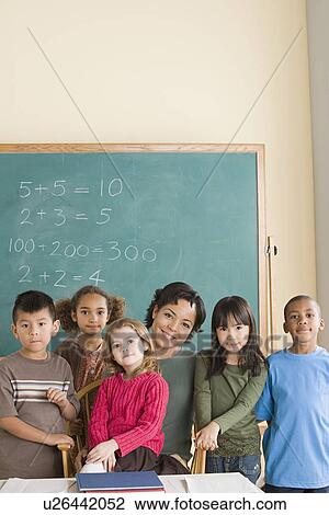 Teacher with children (6-7) at school looking at camera View Large Photo Image Stock Image - Teacher with children (6-7) at school looking at camera. Fotosearch