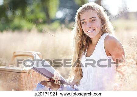 Teenage girl (16-17) posing for portrait while reading book outdoors View Large Photo Image Stock Image - Teenage girl (16-17) posing for portrait while reading book outdoors. Fotosearch