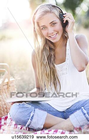 Teenage girl (16-17) posing with book and headphones on View Large Photo Image Stock Photo - Teenage girl (16-17) posing with book and headphones on. Fotosearch