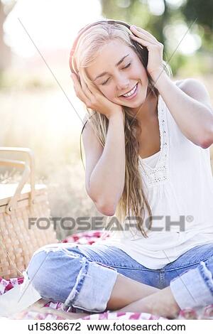Stock Image - Teenage girl (16-17) posing with headphones on. Fotosearch