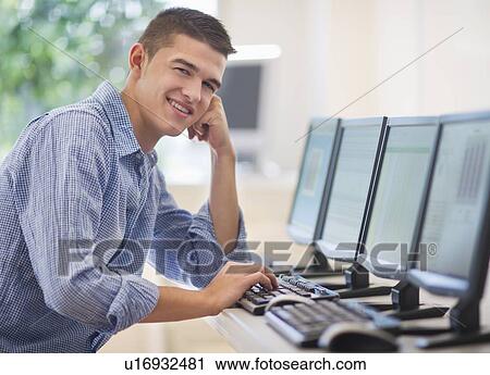 Stock Image - Teenage student (16-17) in computer lab. Fotosearch