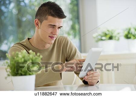 Teenager (16-17) using digital tablet View Large Photo Image Stock Photo - Teenager (16-17) using digital tablet. Fotosearch