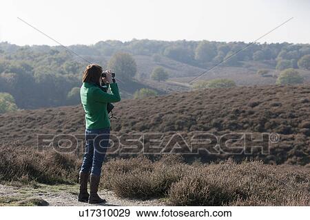 The Netherlands, Veluwezoom, Posbank, Woman in countryside looking through binoculars View Large Photo Image Stock Photo - The Netherlands, Veluwezoom, Posbank, Woman in countryside looking through binoculars. Fotosearch