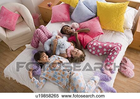 Stock Photography - Three girls (10-11) having fun at slumber party. Fotosearch