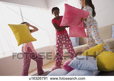Three girls (10-11) having pillow fight at slumber party View Large Photo Image Stock Image - Three girls (10-11) having pillow fight at slumber party. Fotosearch