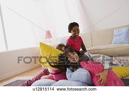 Three girls (10-11) playing on bed at slumber party View Large Photo Image Picture - Three girls (10-11) playing on bed at slumber party. Fotosearch