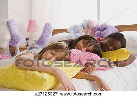 Three girls (10-11) sleeping on bed at slumber party View Large Photo Image Stock Photo - Three girls (10-11) sleeping on bed at slumber party. Fotosearch