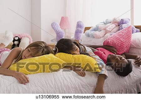 Three girls (10-11) sleeping on bed at slumber party View Large Photo Image Stock Photography - Three girls (10-11) sleeping on bed at slumber party. Fotosearch
