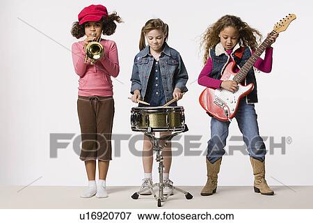Three girls (8-9) playing instruments together, studio shot View Large Photo Image Stock Photo - Three girls (8-9) playing instruments together, studio shot. Fotosearch