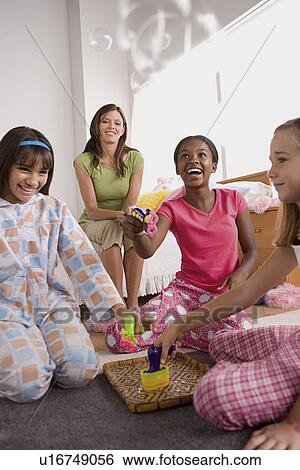 Three girls and woman (10-11) having fun at slumber party View Large Photo Image Stock Photograph - Three girls and woman (10-11) having fun at slumber party. Fotosearch