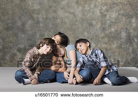 Stock Image - Tired children (6-7, 8-9) lying together, studio shot. Fotosearch