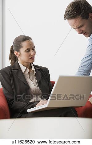 Two business people with laptop in office View Large Photo Image Stock Image - Two business people with laptop in office. Fotosearch