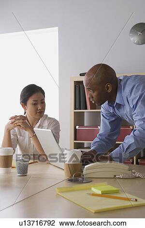 Two business people working in office View Large Photo Image Stock Image - Two business people working in office. Fotosearch