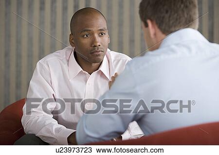 Stock Image - Two businessmen talking. Fotosearch
