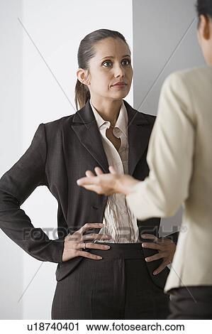Stock Image - Two businesswomenn discussing in office. Fotosearch