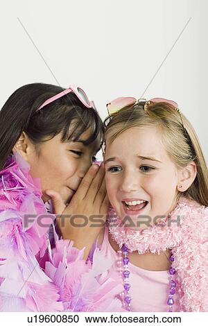 Stock Image - Two girls (10-11) gossiping . Fotosearch