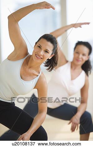 Stock Photo - Two women exercising in gym. Fotosearch