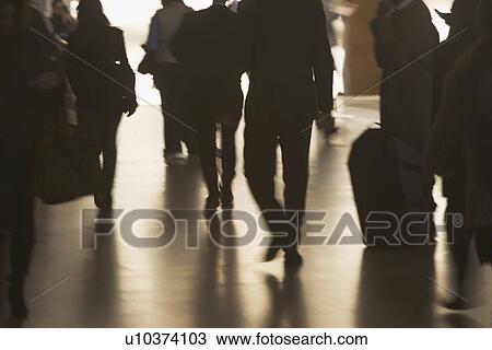 Stock Image - Urban scene with backlit pedestrians . Fotosearch