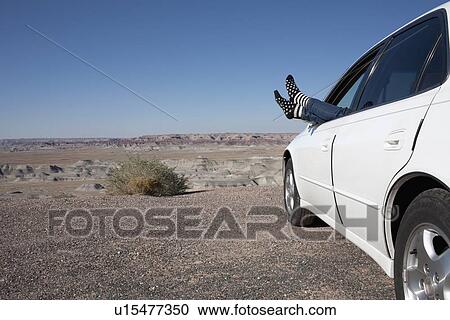 USA, Arizona, Winslow, Woman sticking feet out of car window parked in desert View Large Photo Image Stock Image - USA, Arizona, Winslow, Woman sticking feet out of car window parked in desert. Fotosearch