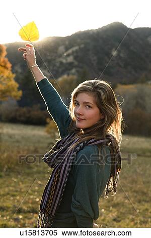 USA, Colorado, Portrait of young woman holding up leaf View Large Photo Image Stock Photography - USA, Colorado, Portrait of young woman holding up leaf. Fotosearch