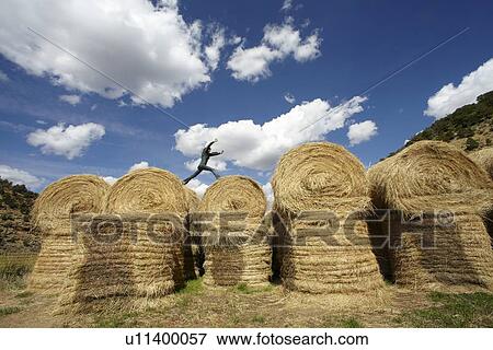 USA, Colorado, Woman jumping on haystacks View Large Photo Image Stock Photo - USA, Colorado, Woman jumping on haystacks. Fotosearch