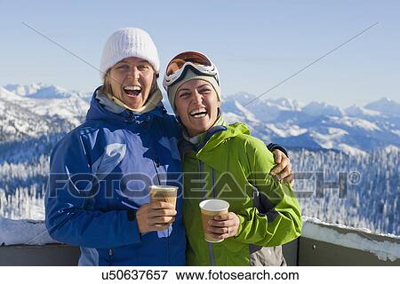 Stock Photo - USA, Montana, Whitefish, Portrait of two women with mountains as backdrop. Fotosearch