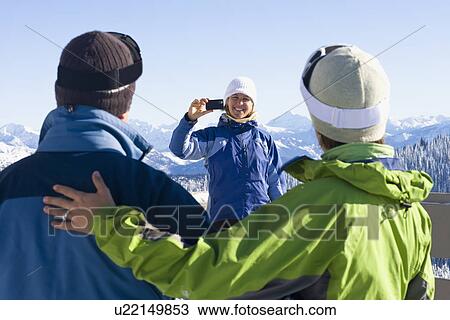USA, Montana, Whitefish, Woman photographing friends in mountain resort View Large Photo Image Stock Image - USA, Montana, Whitefish, Woman photographing friends in mountain resort. Fotosearch