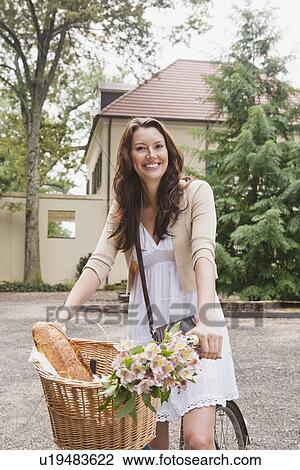 Stock Image - USA, New Jersey, Portrait of woman on bike with basket. Fotosearch