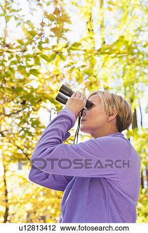 USA, New Jersey, Woman looking through binoculars in Autumn forest View Large Photo Image Stock Image - USA, New Jersey, Woman looking through binoculars in Autumn forest. Fotosearch