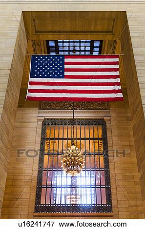 Stock Photo - USA, New York City, Grand Central station interior with US flag. Fotosearch