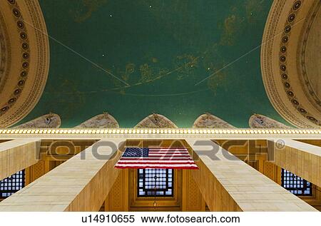 Stock Photography - USA, New York City, Grand Central station interior with US flag. Fotosearch